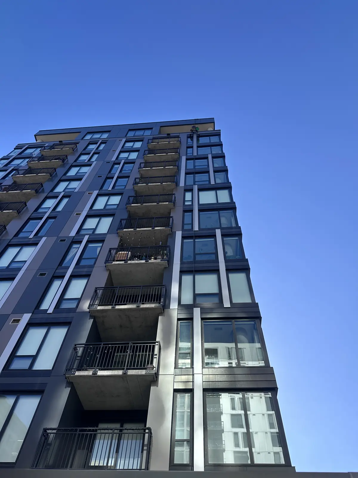 Looking up at The Larking high-rise in downtown Minneapolis with a Starbrite window cleaning technician working at the top of the building